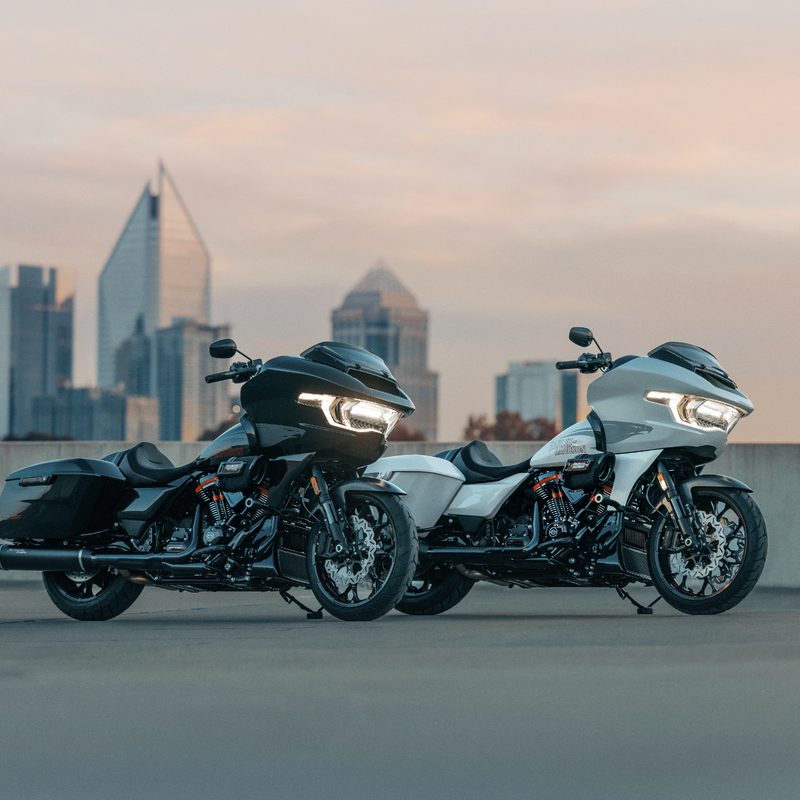 Two 2024 Harley-Davidson CVO Road Glide STs parked on a concrete deck overlooking a city.
