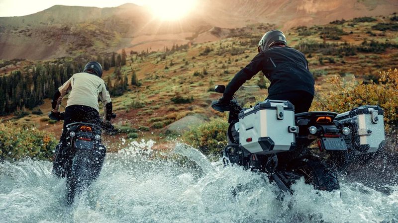 Two riders on 2024 Harley-Davidson Pan America 1250 Special motorcycles driving through water about to climb a sloping hill