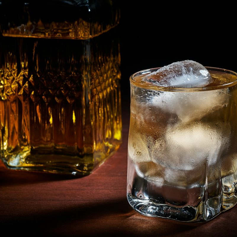 Whiskey in glass next to the bottle