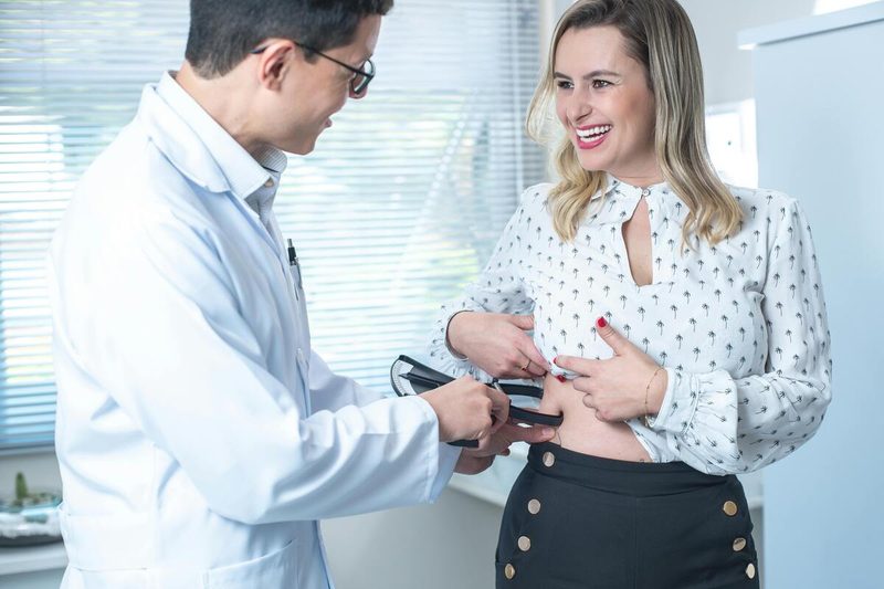 Woman measuring her body fat percentage with calipers.