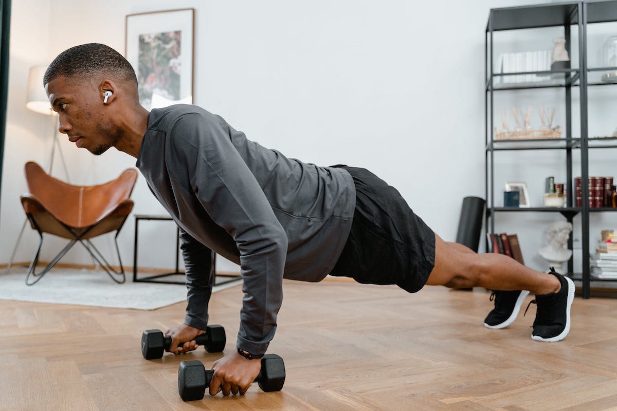 A man doing a plank with dumb bells