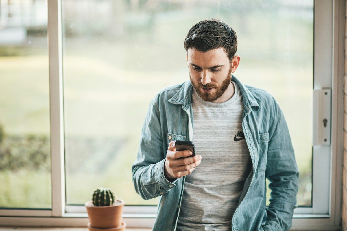 a man looking at his phone in an airy room