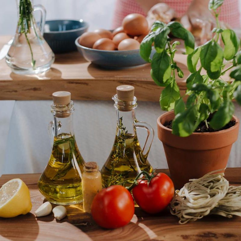 Olive oil on counter by herbs