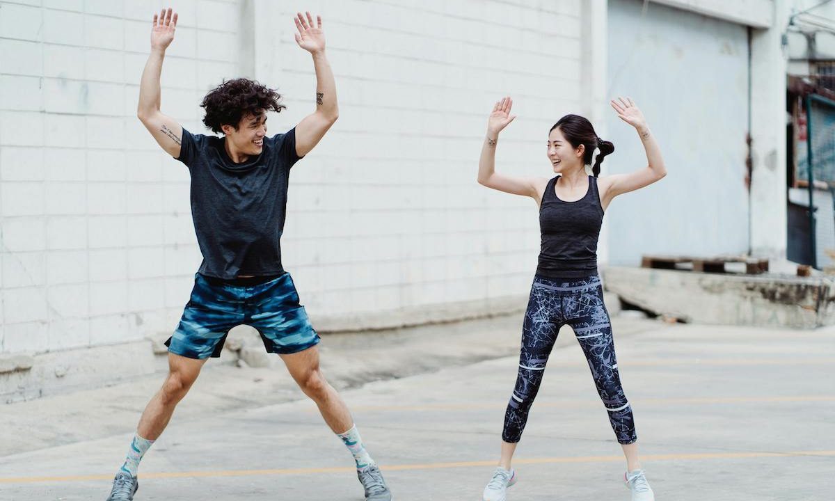 two people doing jumping jacks