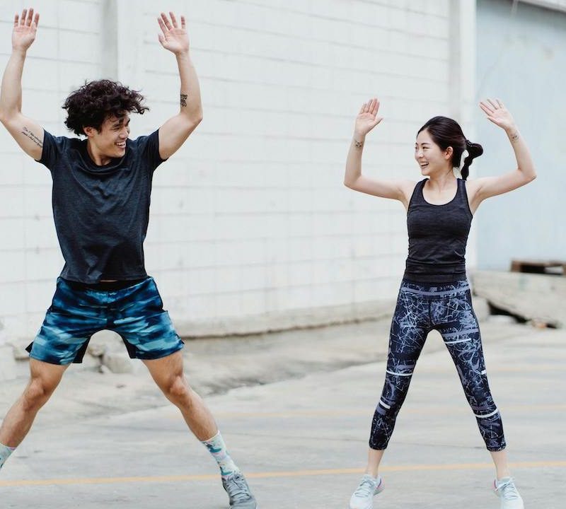 Two people doing jumping jacks