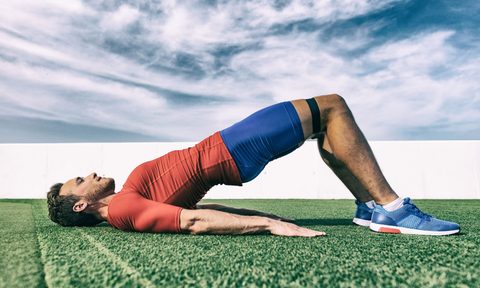 Man doing bridge exercise with a resistance band