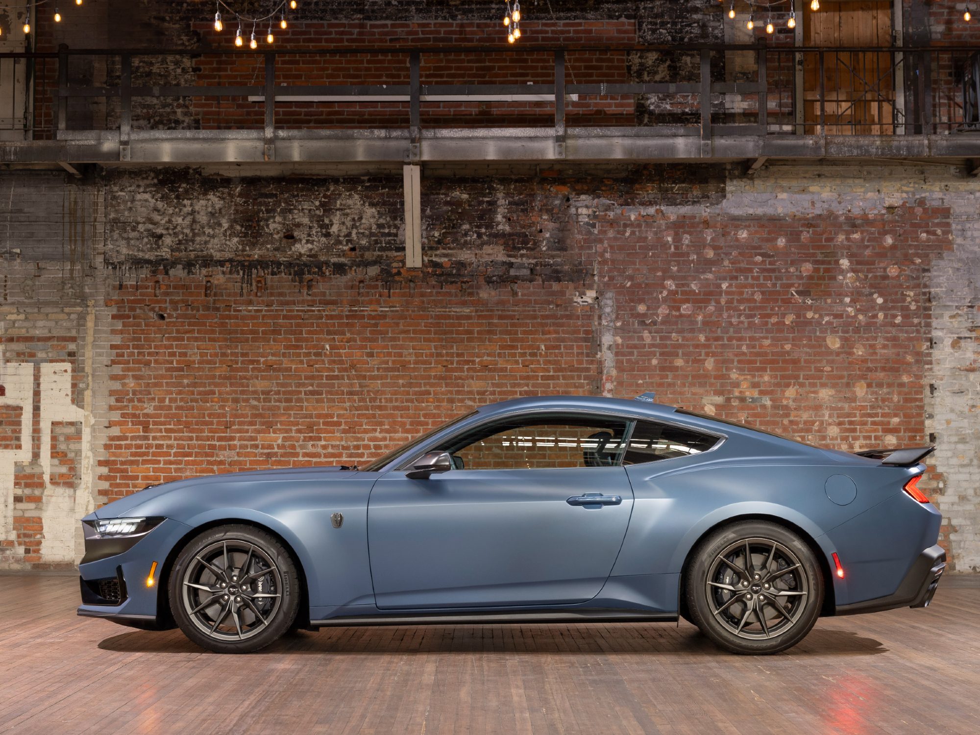 2024 Ford Mustang with Matte Clear Film direct profile view with the car in an empty brick-wall warehouse.