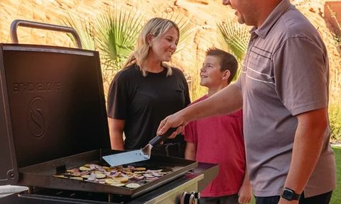 A family cooks on the Blackstone 28-inch propane griddle with air fryer.