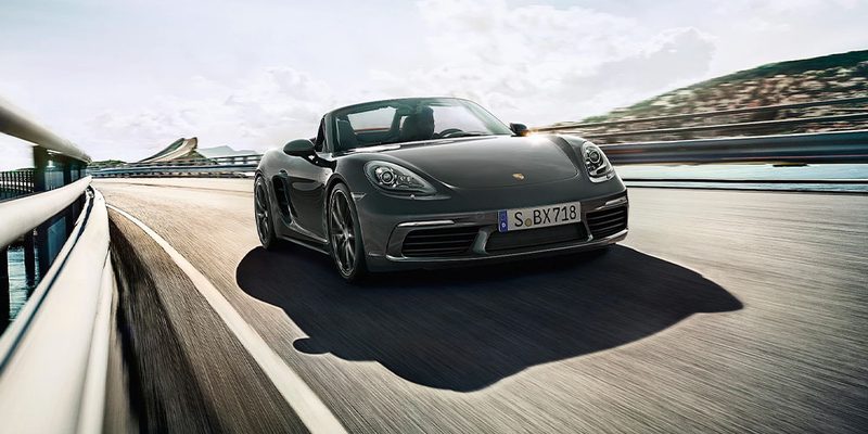 A Porsche 718 driving along a road.