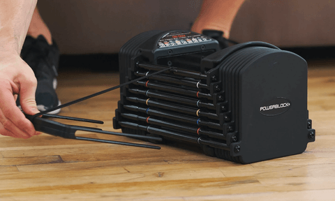 Someone adjusting the weight on a PowerBlock Sport 50 Adjustable Dumbbell.