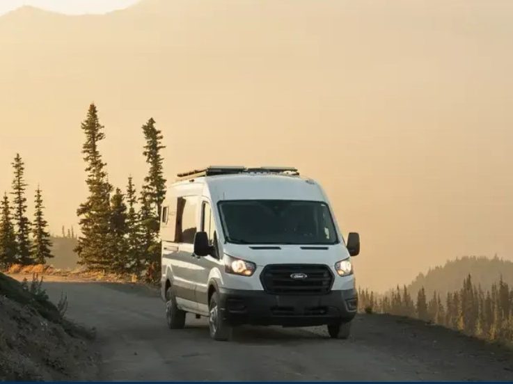 An RVezy-rented RV driving along a scenic path.