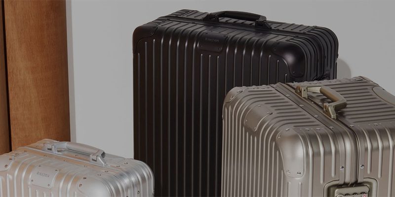 A collection of Rimowa luggage lined up next to each other.