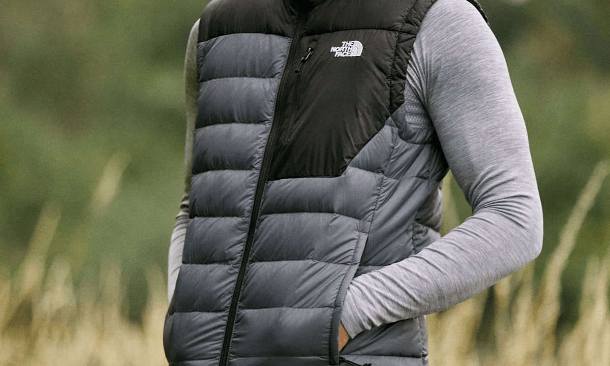 Wearing a North Face vest in a field.