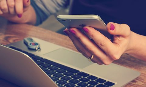 Woman looking at cell phone with network issues -- is AT&T down