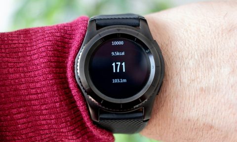 Person outside wearing a black smart watch showing calories