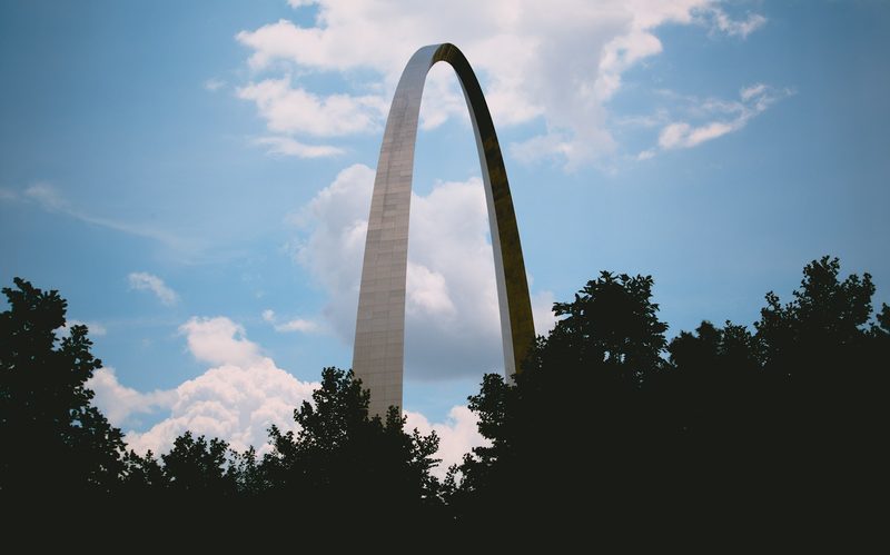 The Gateway Arch National Park monument against sillouhetted clouds