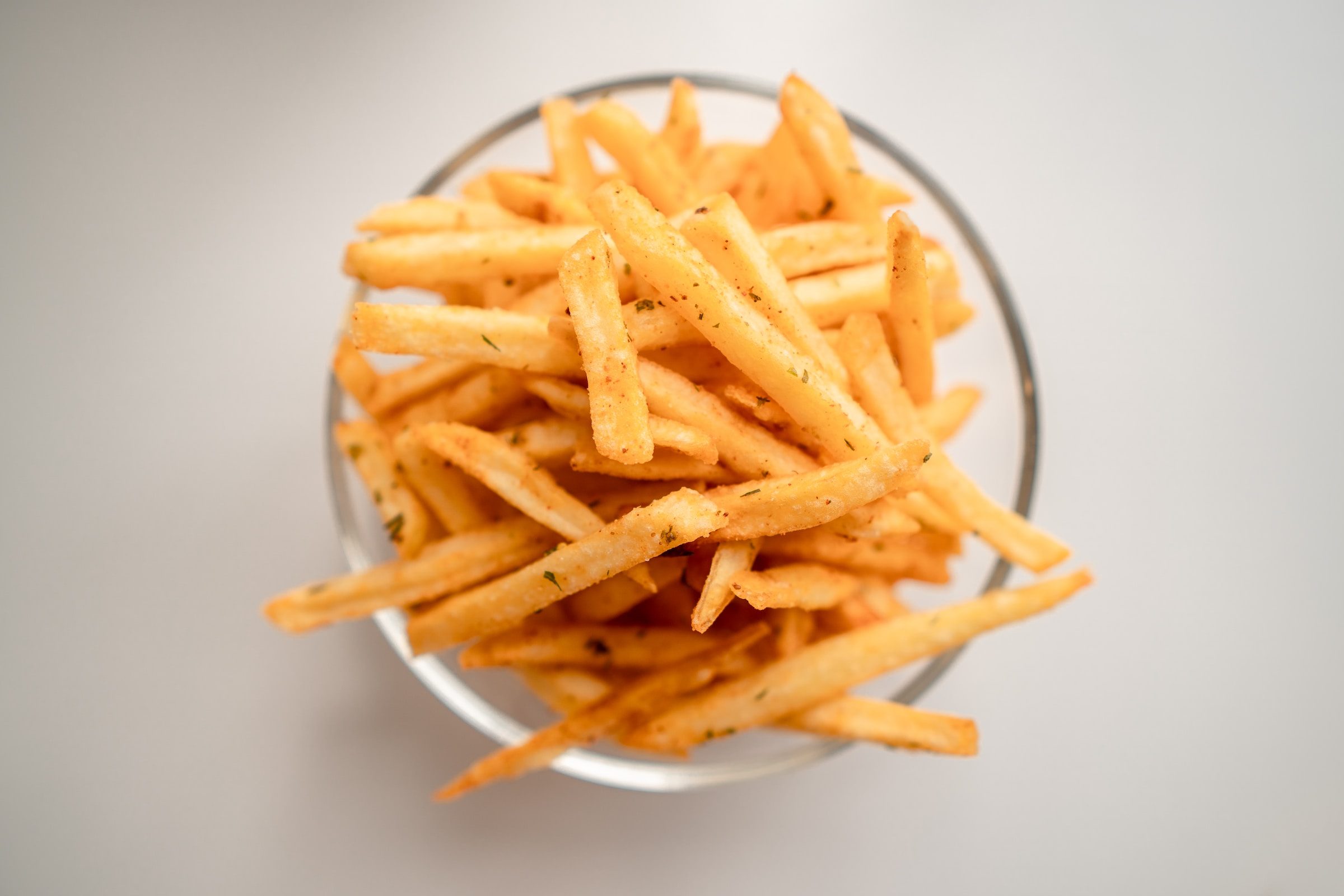 fries in glass bowl on grey background