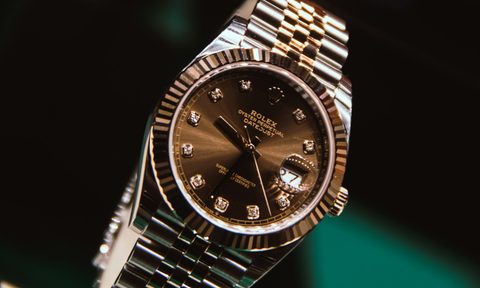 gold and silver rolex watch in air