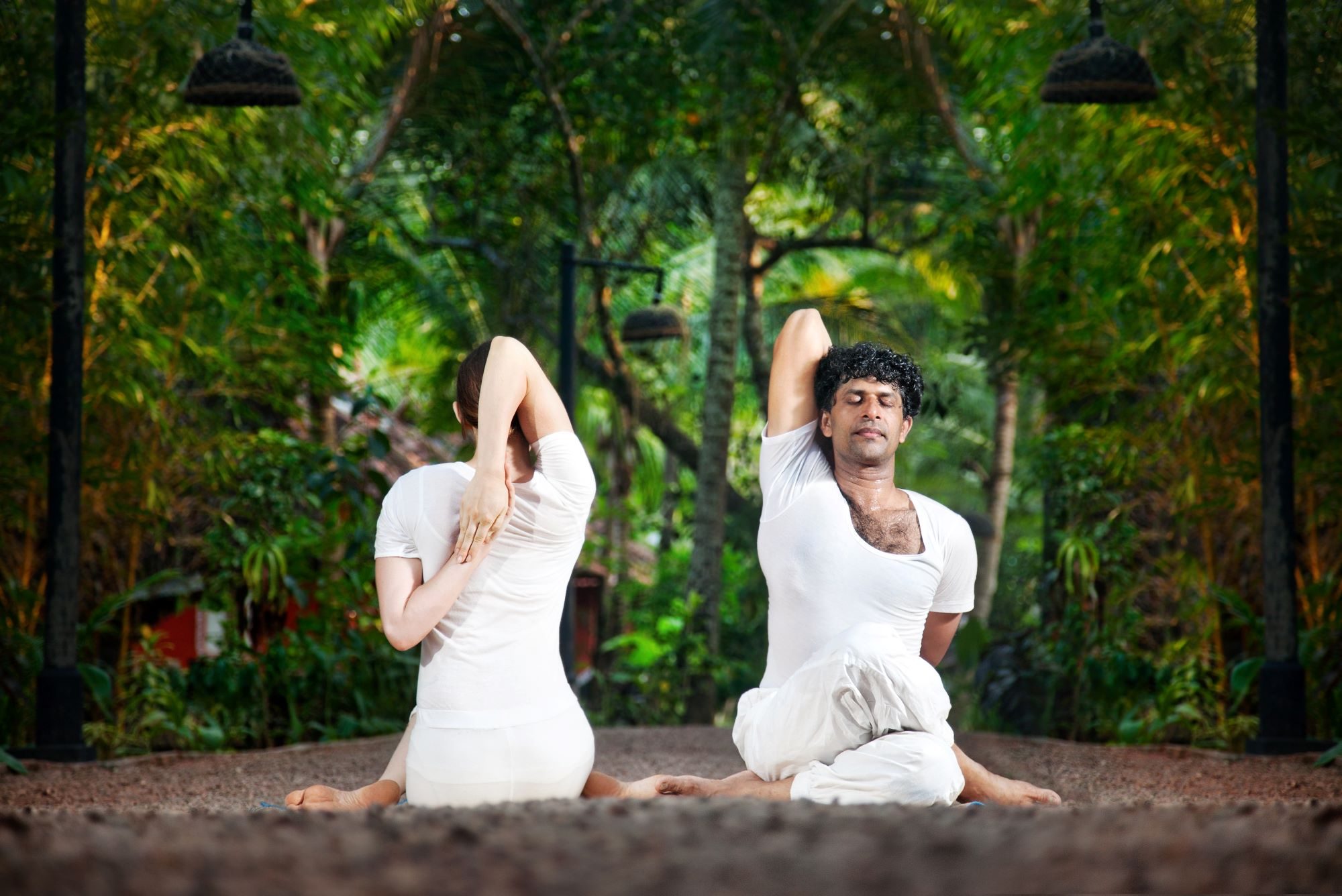 man doing cow face yoga pose outside