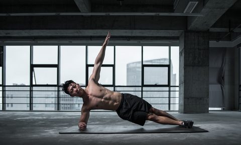 a man doing a side plank black shorts