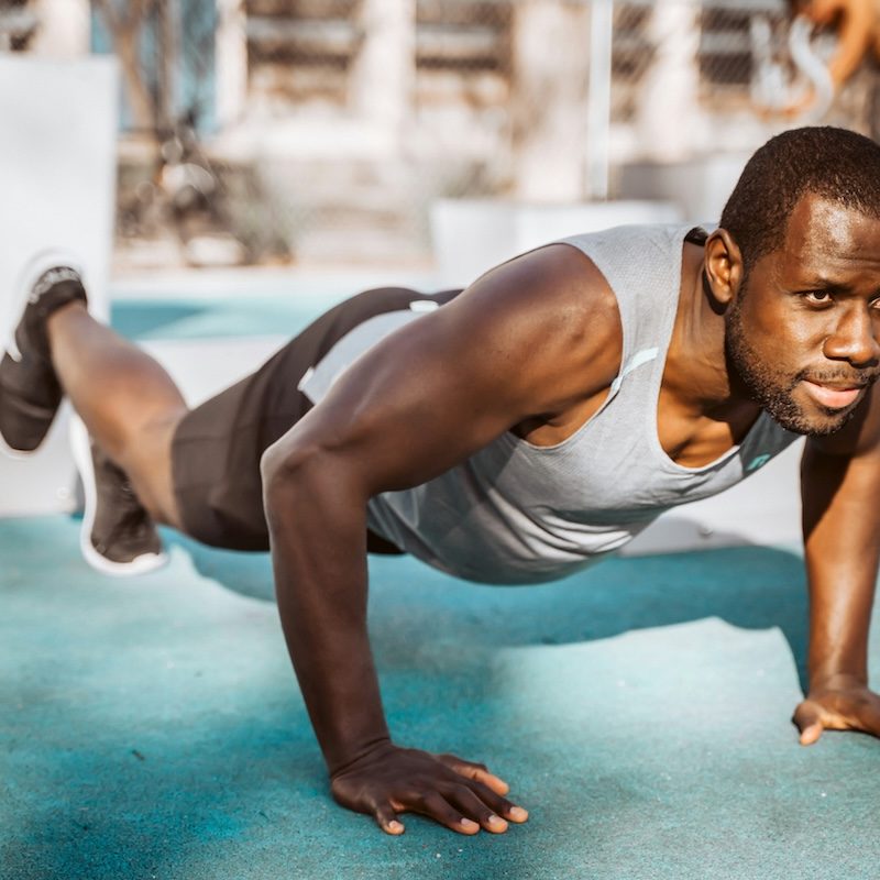 A man in plank pose gray shirt