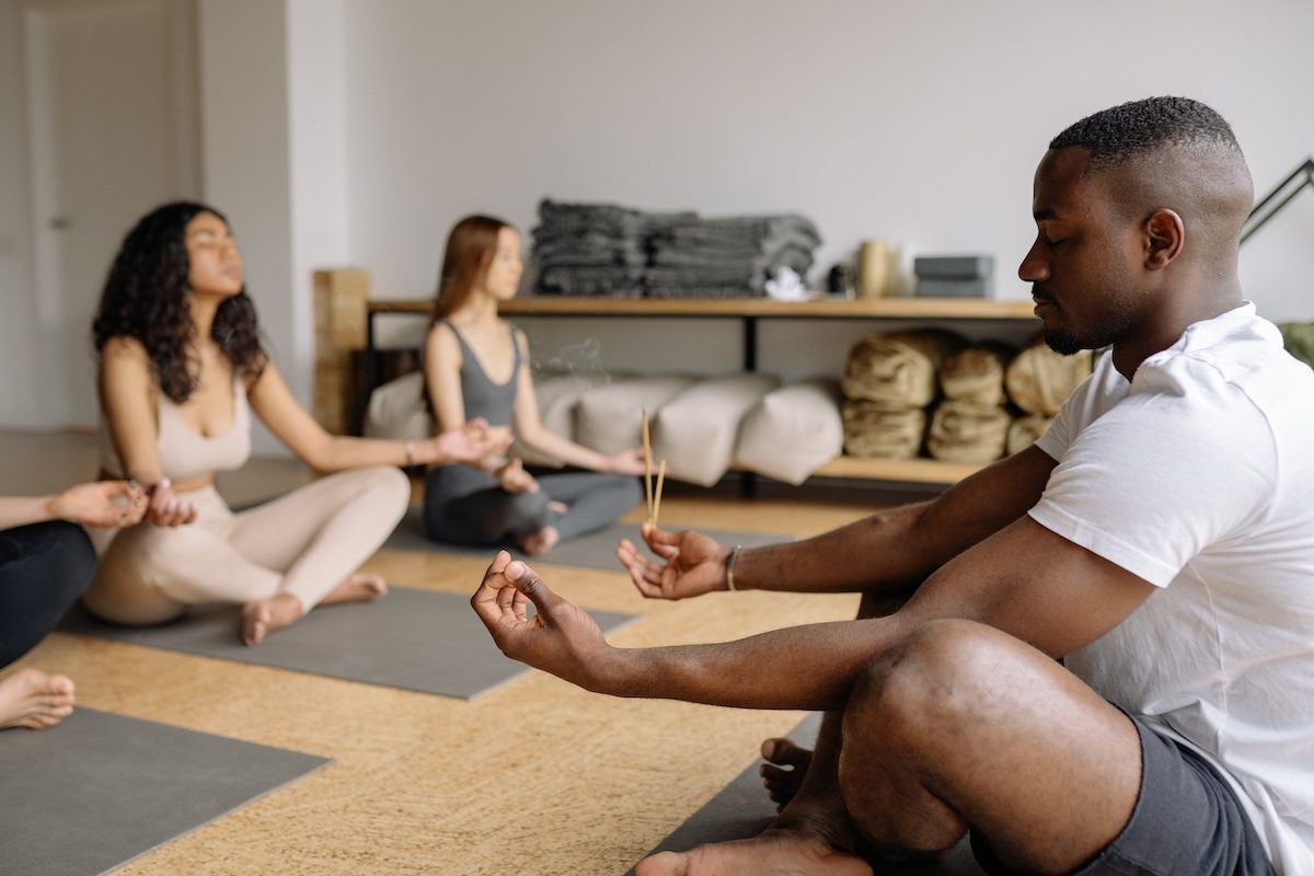 a man in yoga class in easy pose