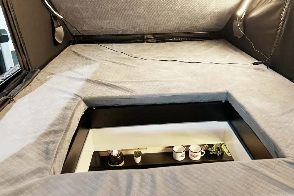 "Trap door" hatch inside the sleeping quarters of the Sportcaravan Cube 1 micro travel trailer.