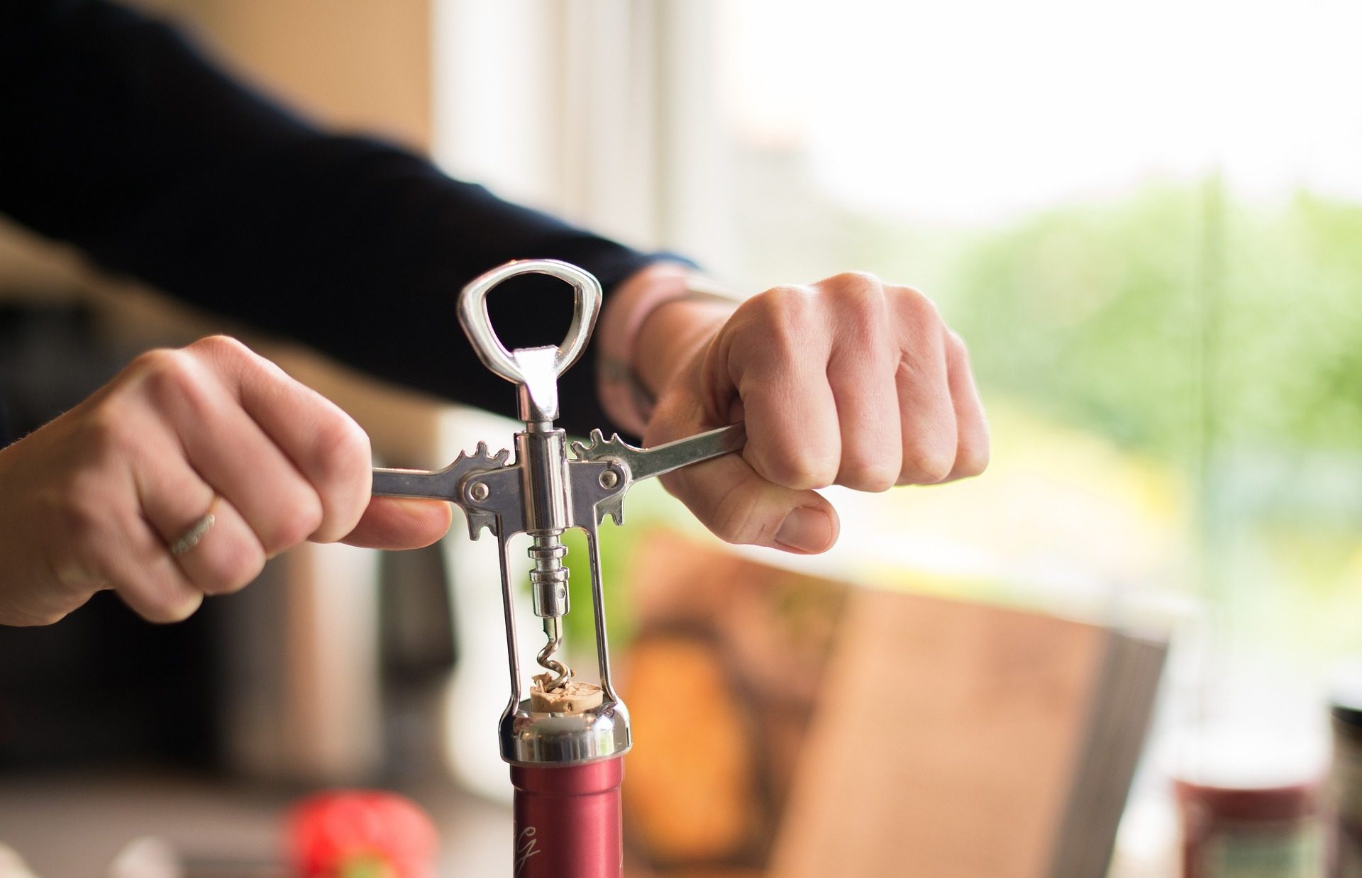Person opening wine bottle
