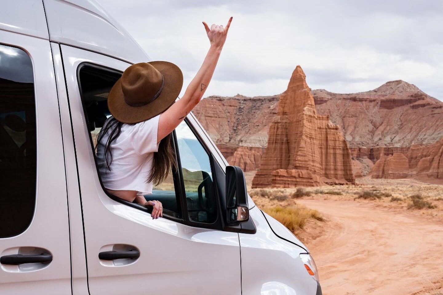 Woman hanging out of a Moterra Campervans rental van at a Utah National Park.