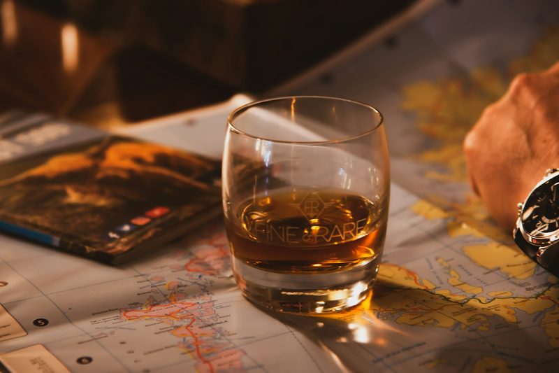 Whiskey in a glass next a person