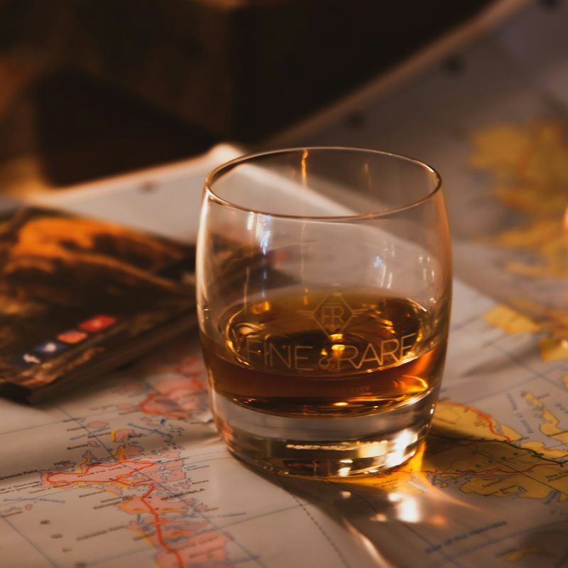Whiskey in a glass next a person