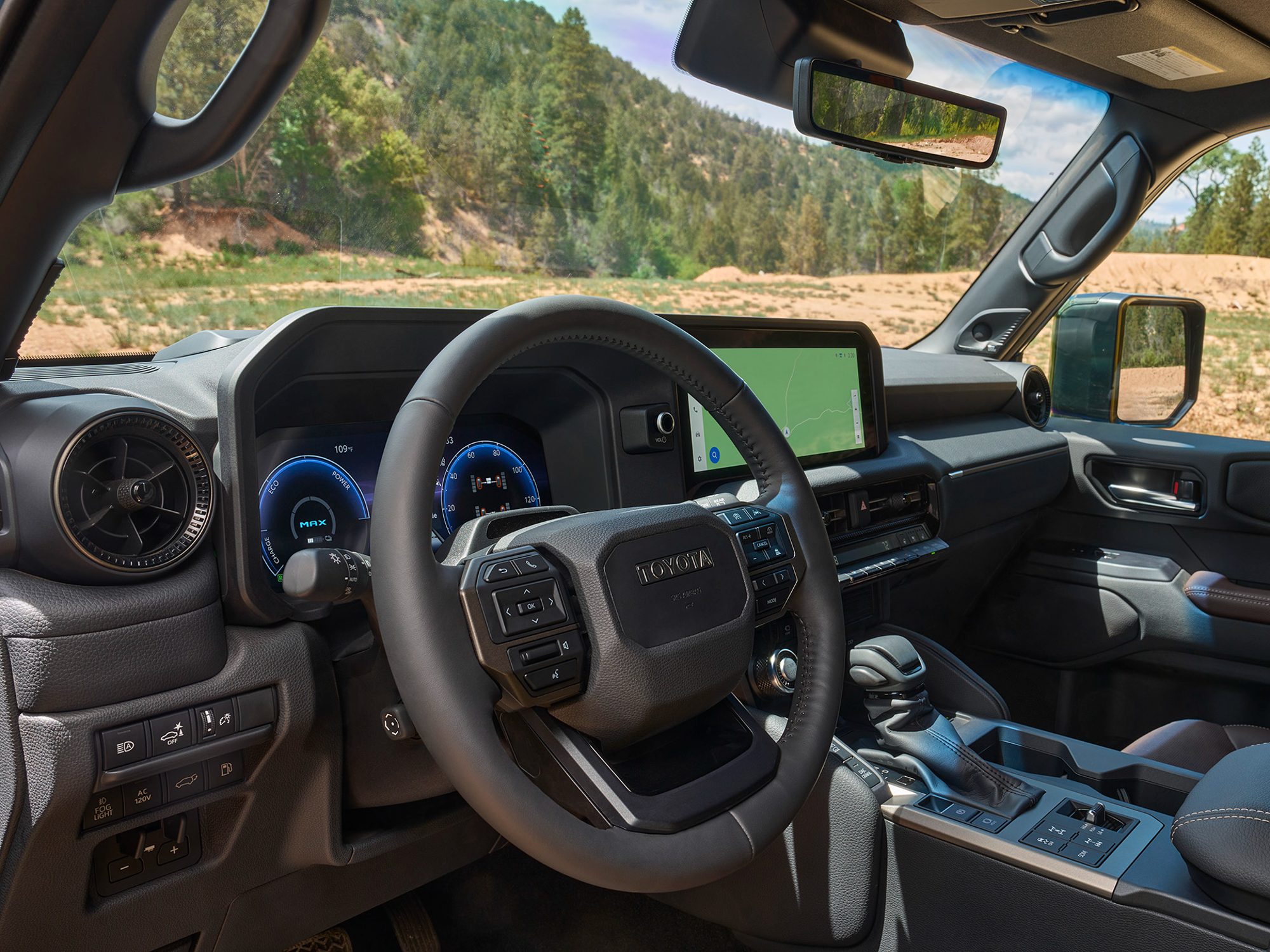 An interior shot of a 2024 Toyota Land Cruiser with a view of the driver's cockpit and across the dashboard toward the front passenger side.