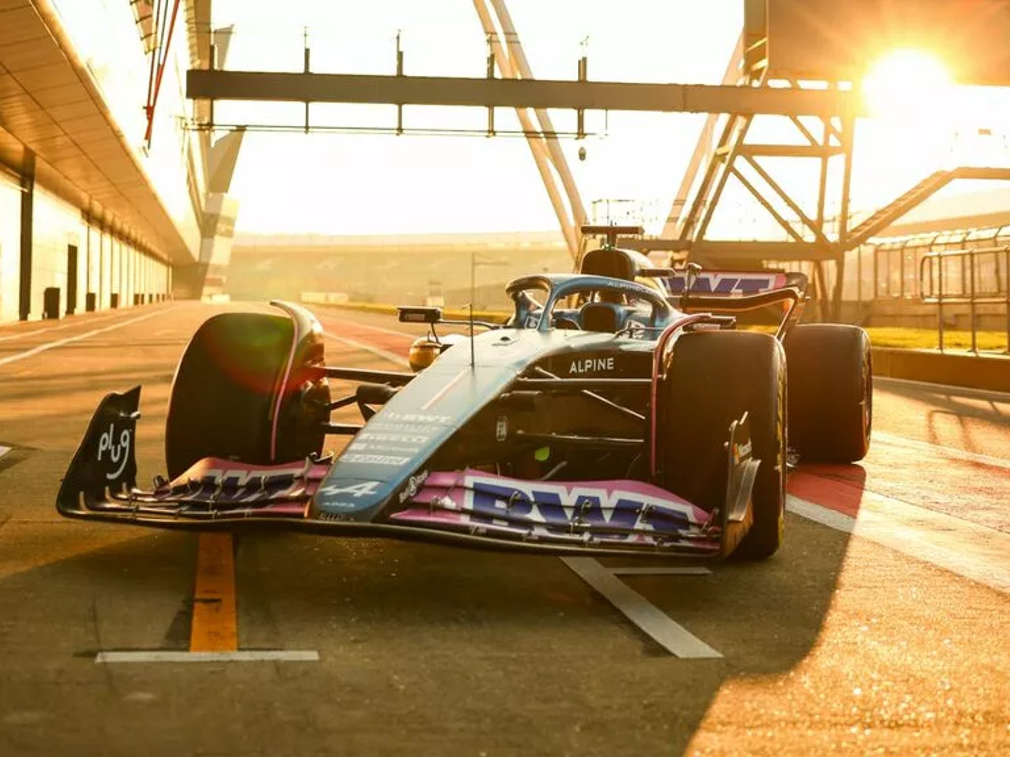BWT Alpine Formula 1 race car sitting on a Grand Prix paddock drive.