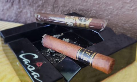 JFR Maduro cigar up close and lit with Aganorsa Rare Leaf Reserve Maduro behind