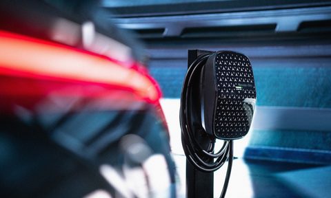 Mercedes-Benz Wallbox home EV charger in a garage behind a car with its taillights on.
