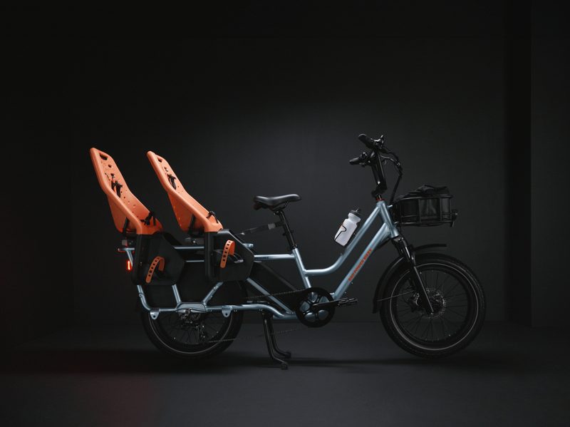 Rad Power Bikes RadWagon 5 cargo bike with two child seats, front basket and bag, and a water bottle.