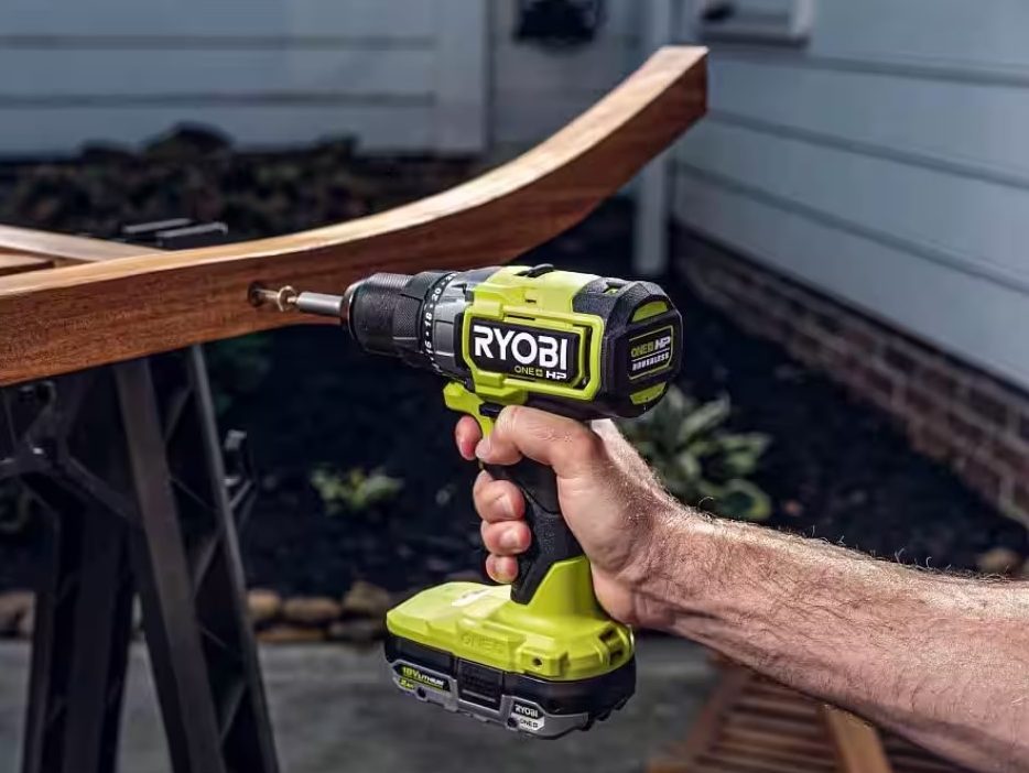 The Ryobi One+ HP Brushless Drill Driver being used one-handed to drill into some wood.
