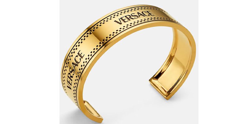 The Versace 90s Vintage Versace Logo Cuff Bracelet on a white background.
