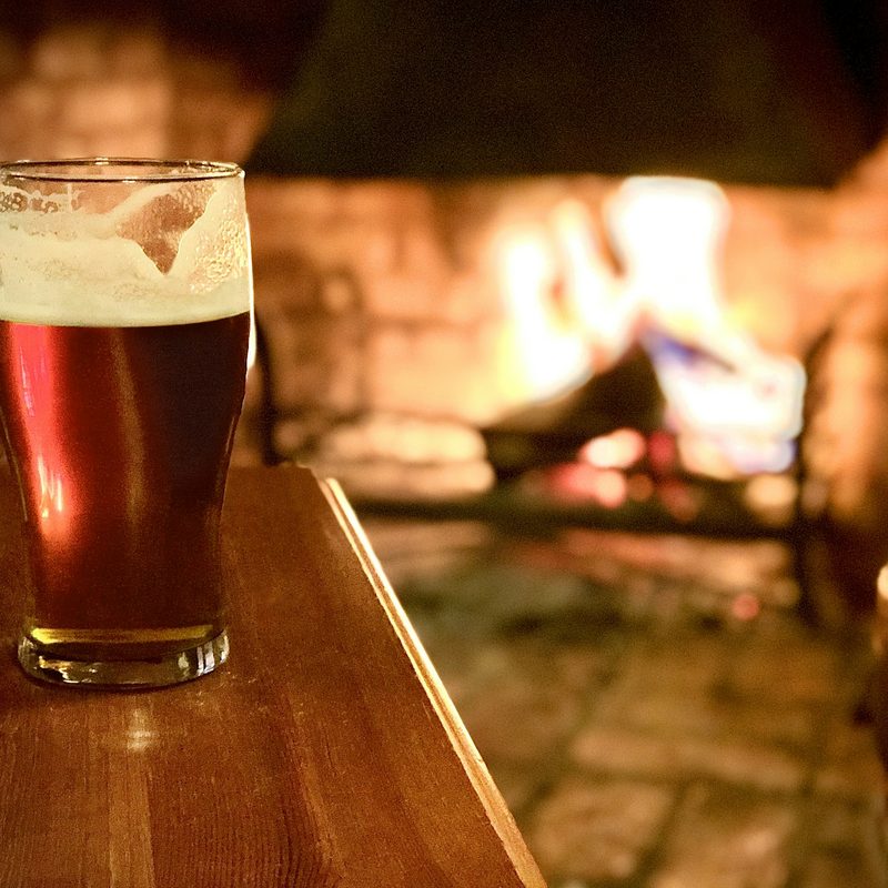 Beer with a fireplace in the background