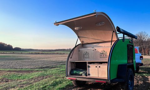 HYK Outdoors teardrop trailer camper parked in a field.