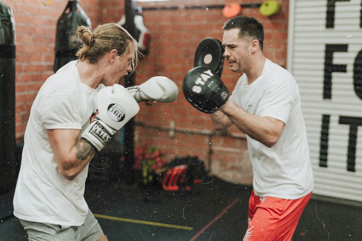 Man boxing with trainer.