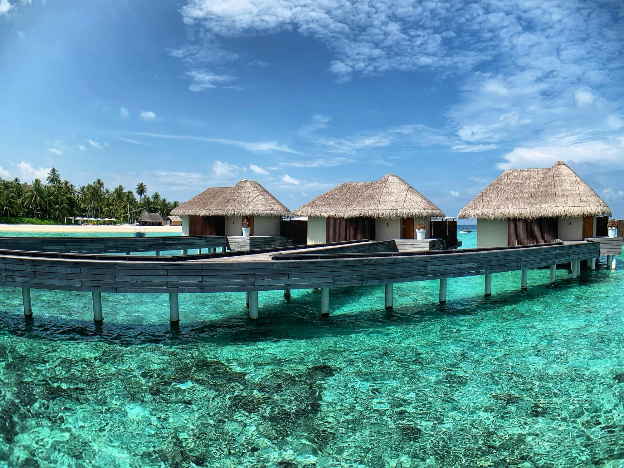 three overwater bungalows above ocean