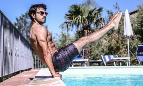 Man with strong abs by a pool