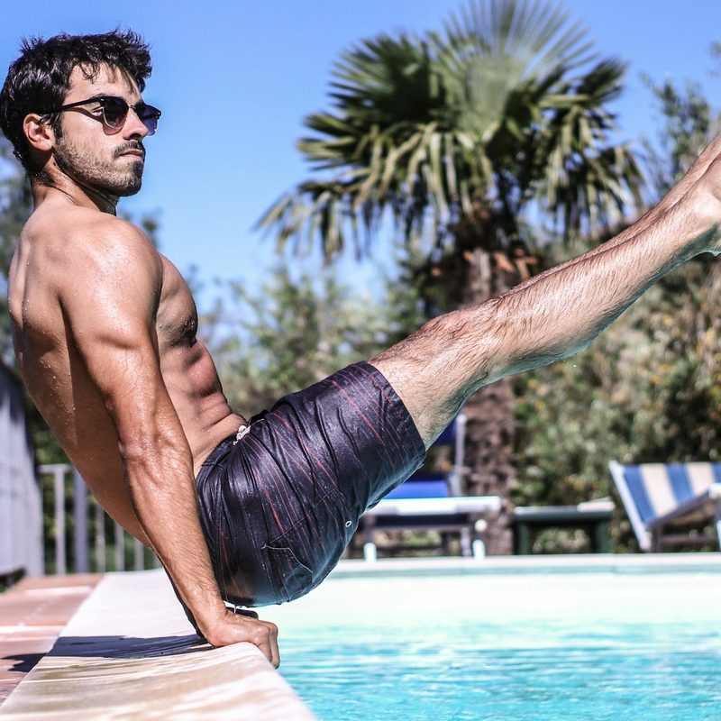 Man with strong abs by a pool