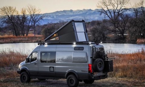 Redtail Overland Skyloft Campervan parked next to a river.
