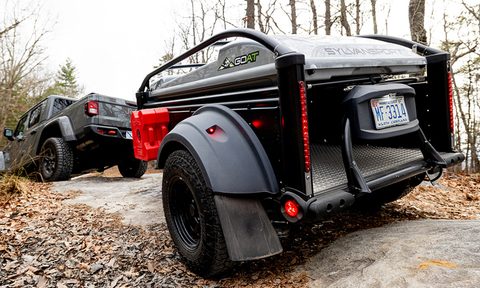 Rear view of SylvanSport's GO All-Terrain Camper Trailer being towed by a Jeep.
