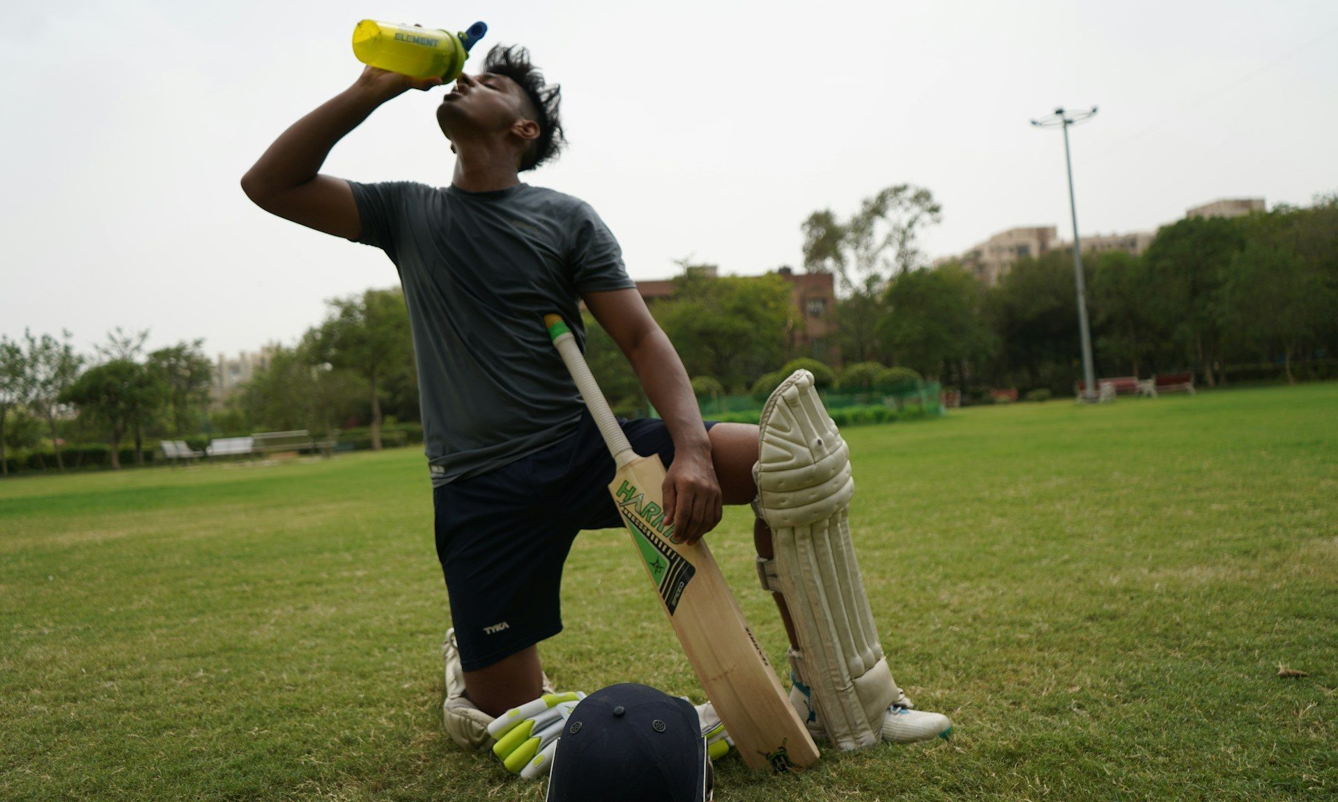 man drinking water while playing sports