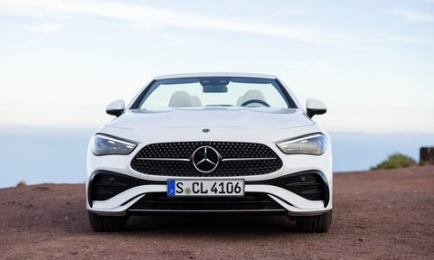 2024 Mercedes-Benz CLE Cabriolet in white direct frontal view parked on red ground with clouds and sky in the background.