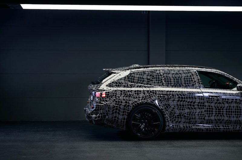 2025 BMW M5 Touring right side from passenger mirror back of a camoflaged (European model).