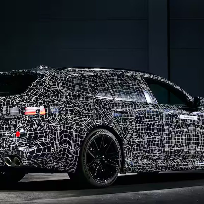 2025 BMW M5 Touring right side three-quarter view of a camoflaged European model.